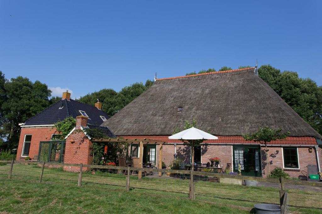 a large brick house with a black roof at Blier Herne in Gorredijk