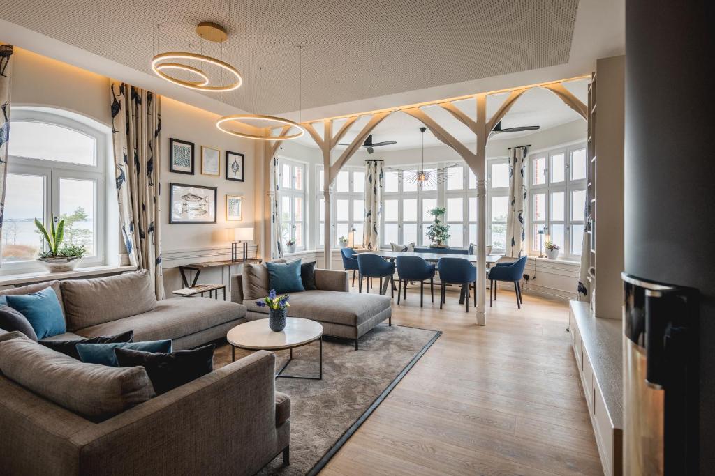 a living room with couches and a dining room at Goldmädchen 93 - Beletage in Timmendorfer Strand
