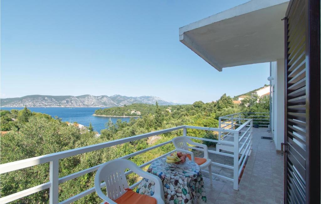 a balcony with a table and chairs and a view of the water at Lovely Apartment In Racisce With House A Panoramic View in Račišće