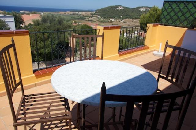 een witte tafel en stoelen op een balkon met uitzicht bij Petit Paradis in Son Bou