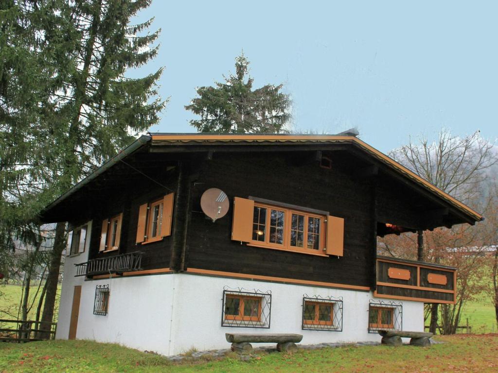una piccola casa con tetto nero e finestre di Holiday home in Sibratsgf ll in the Bregenzerwald a Sibratsgfäll