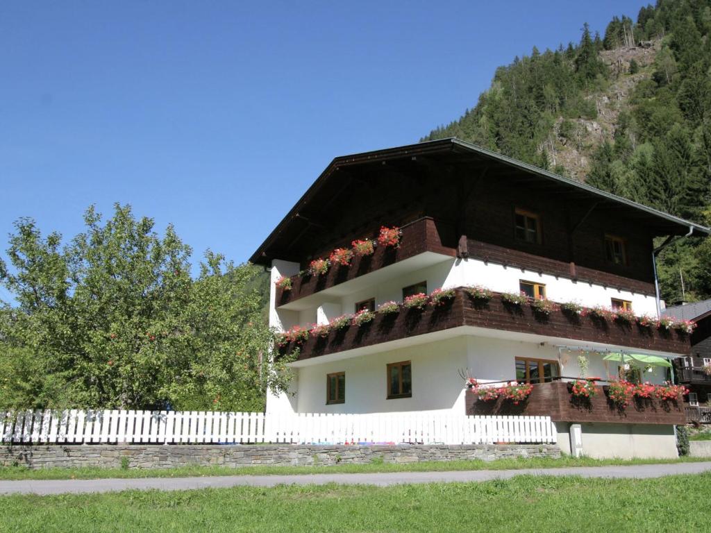 a building with flower boxes and a white fence at Apartment near the ski area in Matrei in Matrei in Osttirol