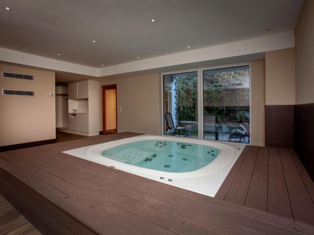 ザンクト・アントン・アム・アールベルクにあるCountry house in Sankt Anton am Arlberg with saunaの大きな窓付きの客室で、ジャクジータブが備わります。