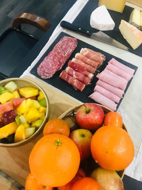 a table with a bowl of fruit and other foods at Hôtel Mont Thabor Serre Chevalier in La Salle-les-Alpes