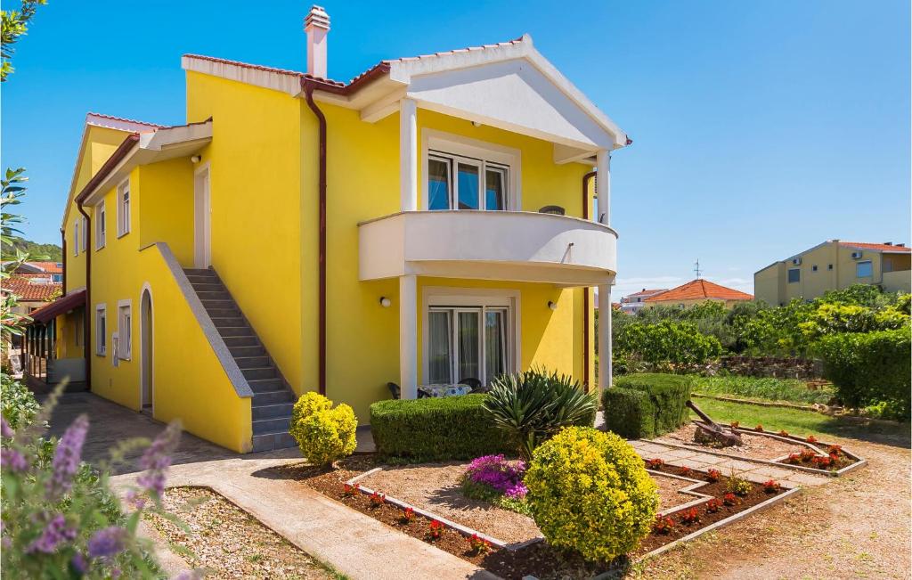 a yellow house with a balcony on the side of it at Cozy Home In Tribunj With Wifi in Tribunj