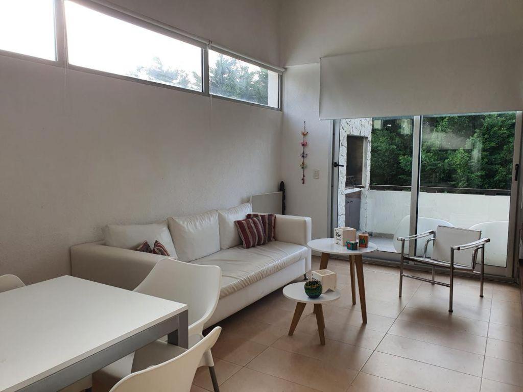 a living room with a couch and a table at Punta vacaciones -piscina solo en vacaciones y fines de semana largos- in Las Gaviotas