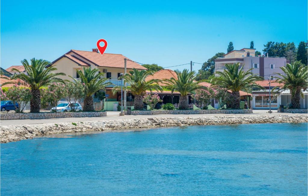 a river in front of houses with a red arrow on top at Holiday Home Crljenica Bb Cr in Bibinje