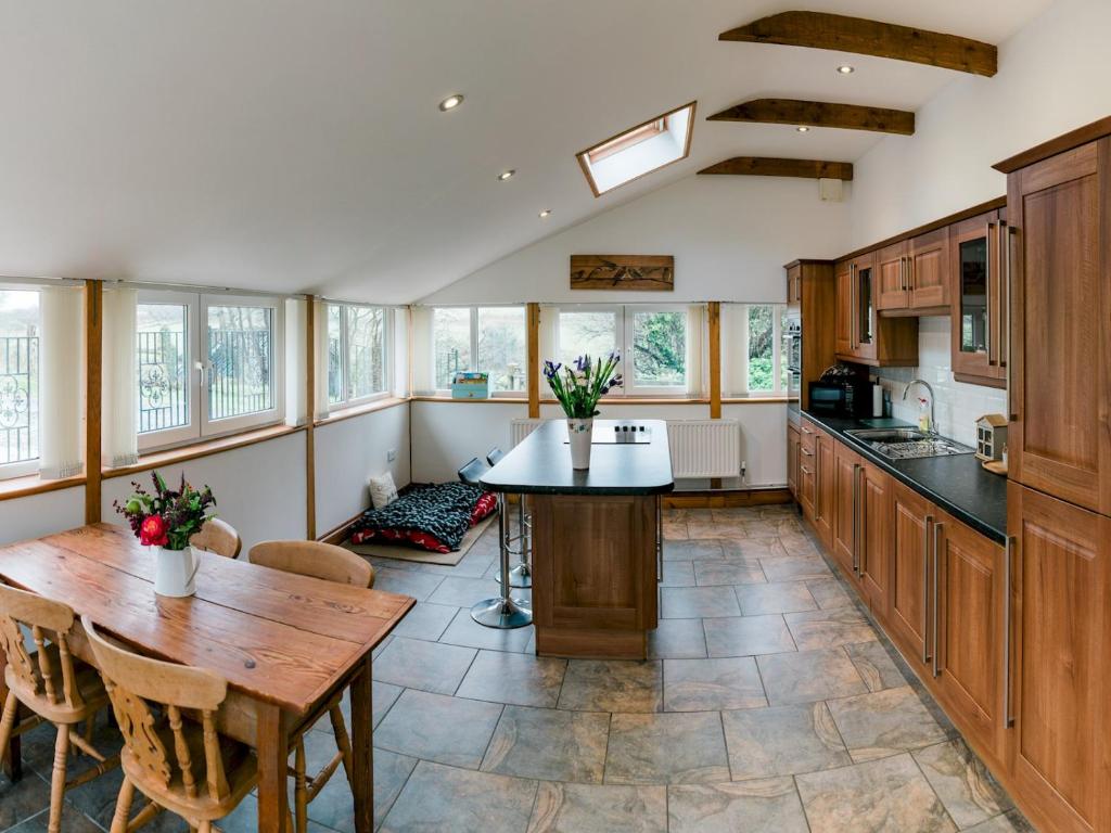 a large kitchen with a wooden table and a dining room at Pass the Keys Peaceful & coastal 2 bedroom cottage in Cardigan