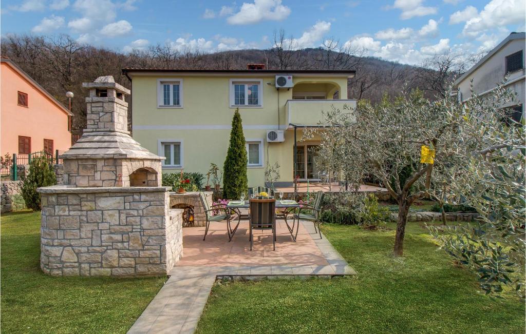 una casa con chimenea de piedra en un patio en Lovely Apartment In Porozina With Kitchen en Porozina