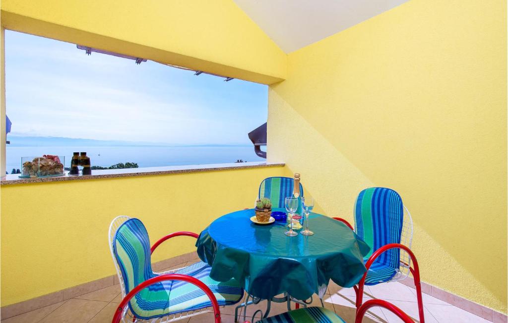 a dining room with a blue table and chairs at Nice Apartment In Opatija With House Sea View in Opatija