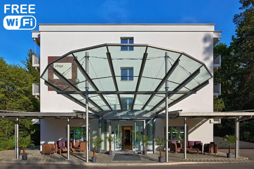 a large white building with a large window at Apart-Hotel Zurich Airport in Opfikon