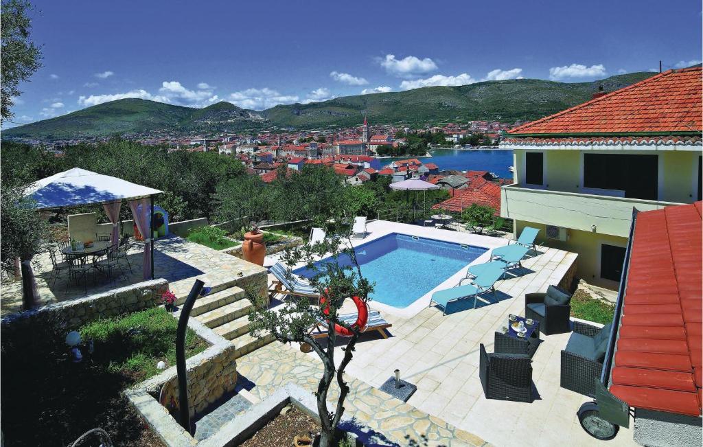 a villa with a swimming pool and a house at 2 Bedroom Gorgeous Apartment In Trogir in Trogir