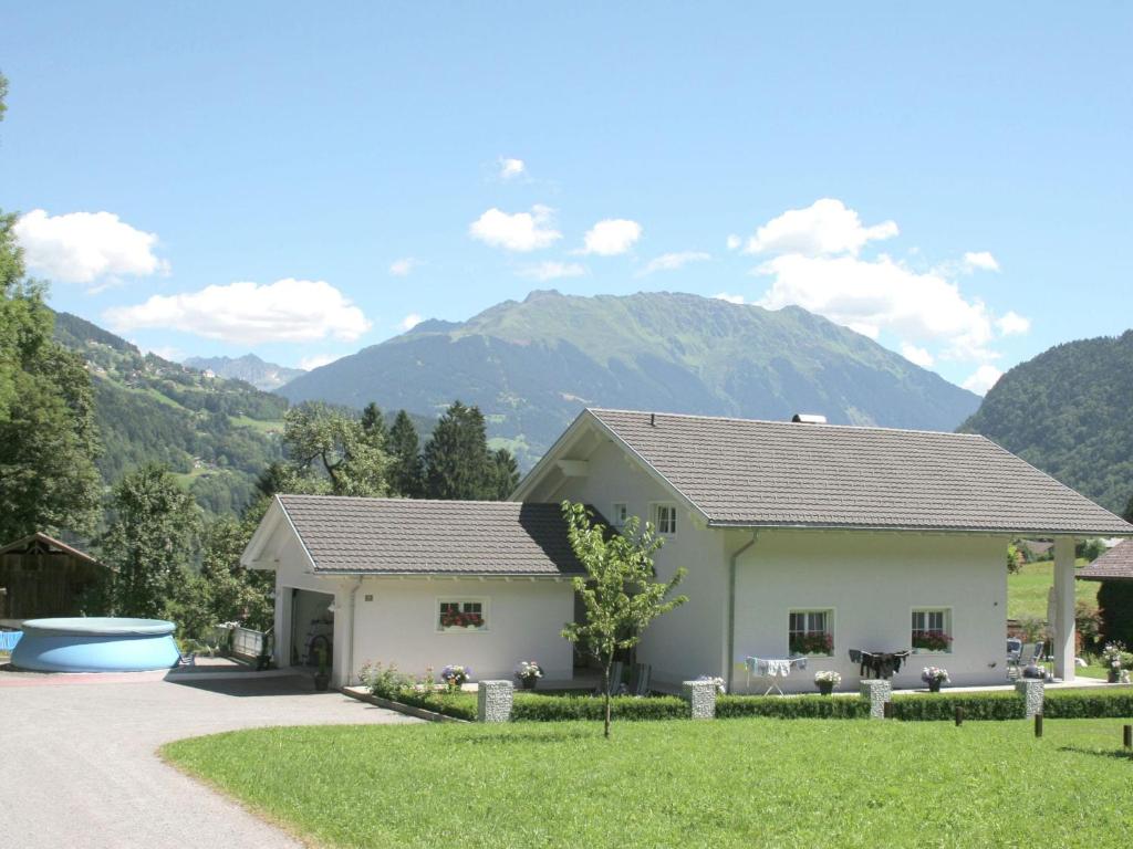 a white house with mountains in the background at Holiday home near the ski area in Vandans in Vandans