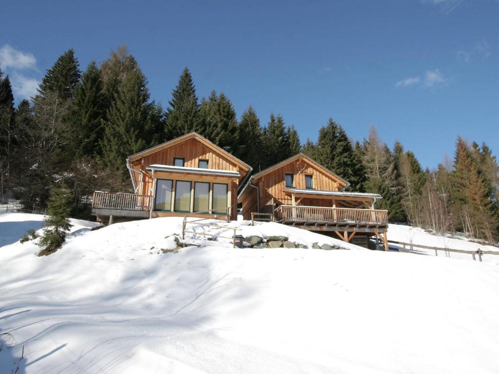 eine Blockhütte im Schnee mit Bäumen in der Unterkunft Detached wooden chalet in Stadl an der Mur Styria facing south with sauna in Stadl an der Mur