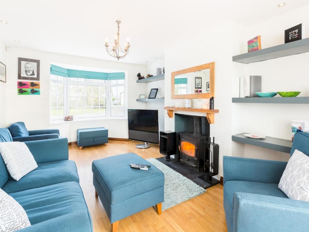 a living room with blue couches and a fireplace at Pass the Keys SPACIOUS Modern 5 Bed, Sleeps up to 12 & Parking in Warwick