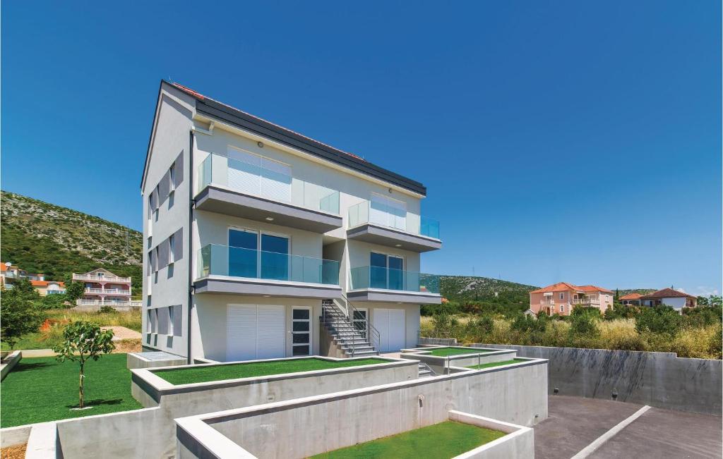 une grande maison blanche avec une cour dans l'établissement Nice Apartment In Trogir With Kitchen, à Trogir