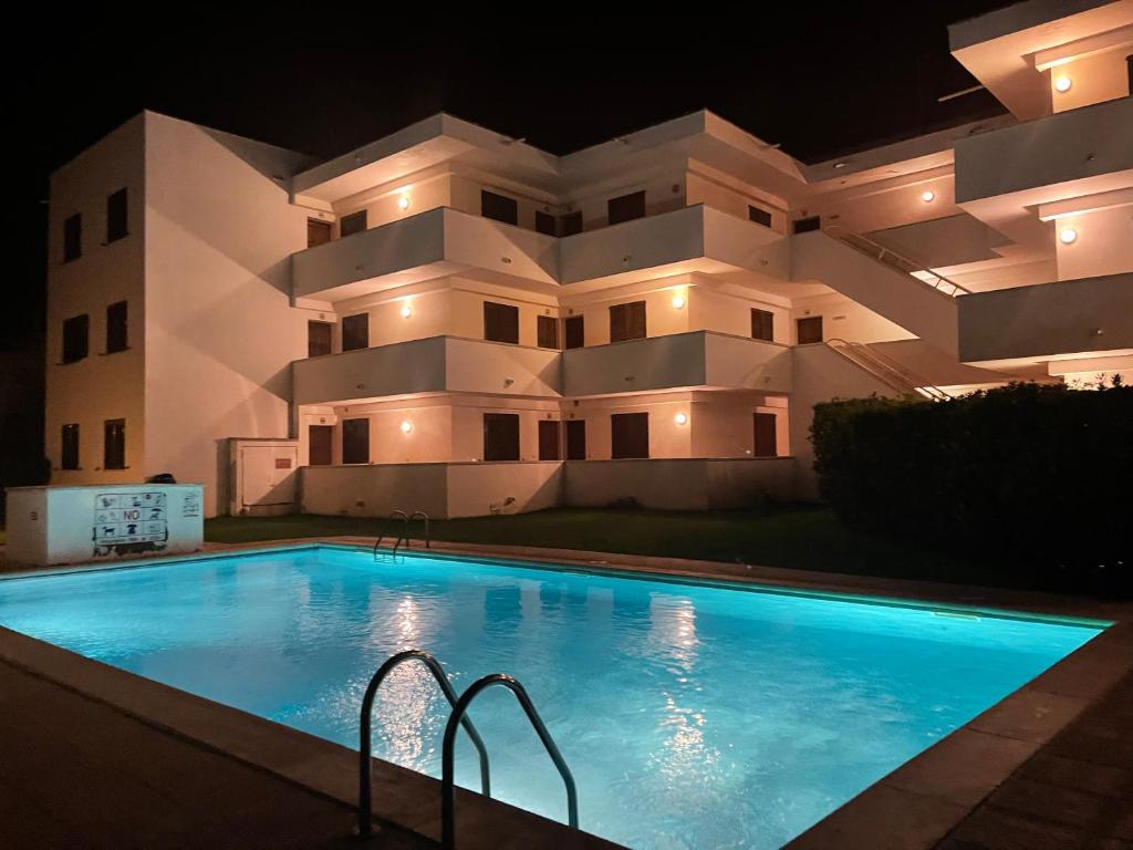 a building with a swimming pool in front of a building at Résidence Cala Montgo in L'Escala