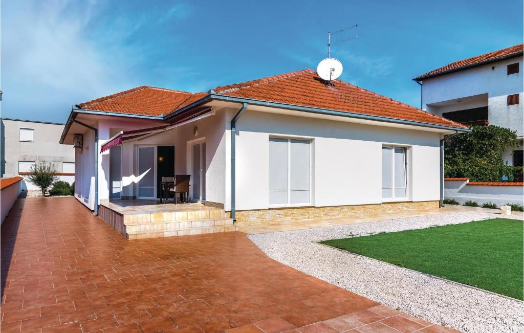 a house with a red roof and a brick driveway at Nice Home In Vodice With Kitchen in Vodice