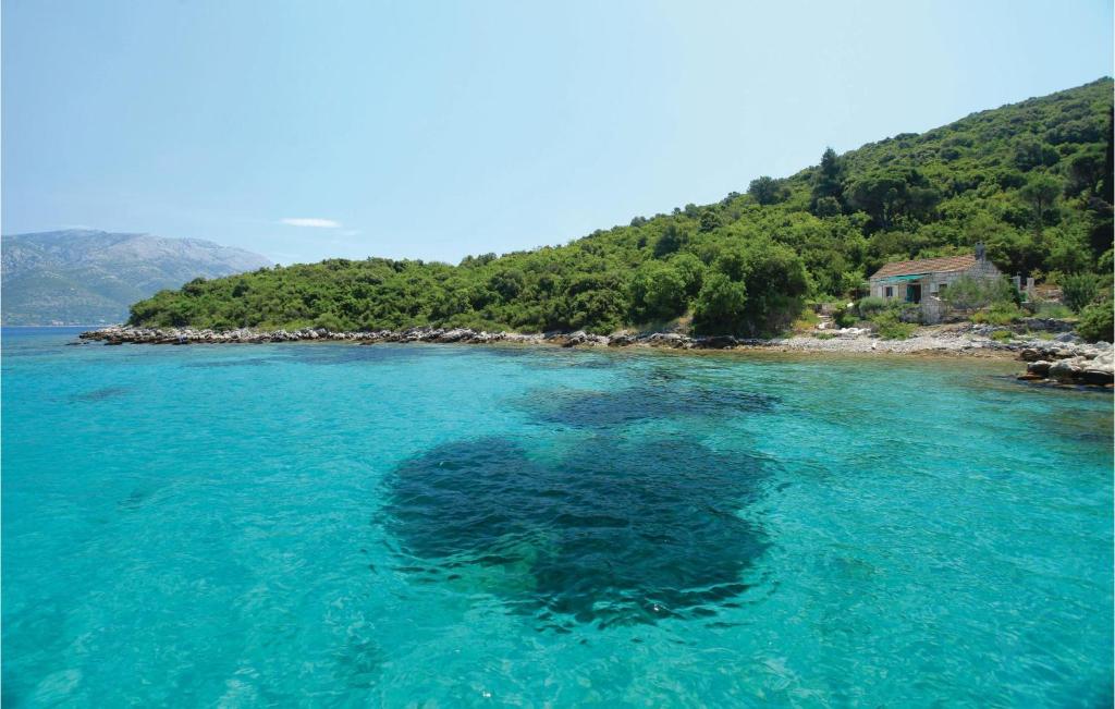 um grande corpo de água azul ao lado de uma montanha em Lovely Home In Korcula With Kitchen em Korčula