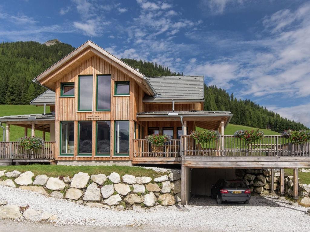 ein Holzhaus mit einem davor geparkt in der Unterkunft Chalet in Hohentauern Styria with sauna in Hohentauern