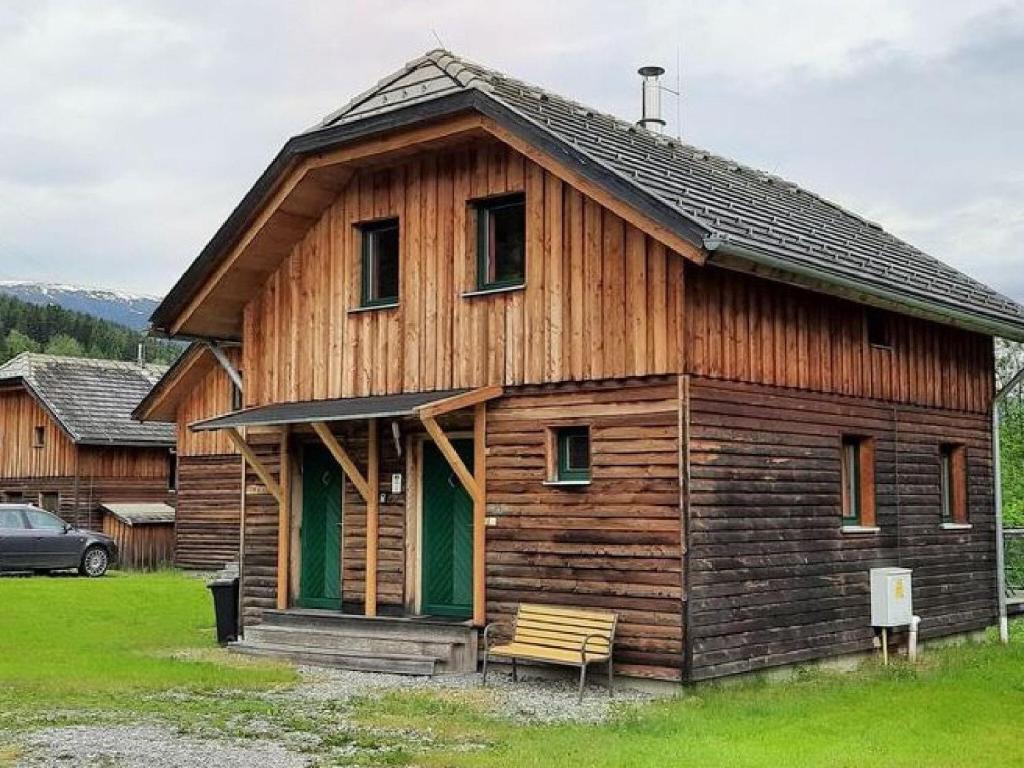 ein Holzhaus mit einer Bank davor in der Unterkunft Chalet in St Georgen ob Murau with hot tub in Sankt Georgen ob Murau