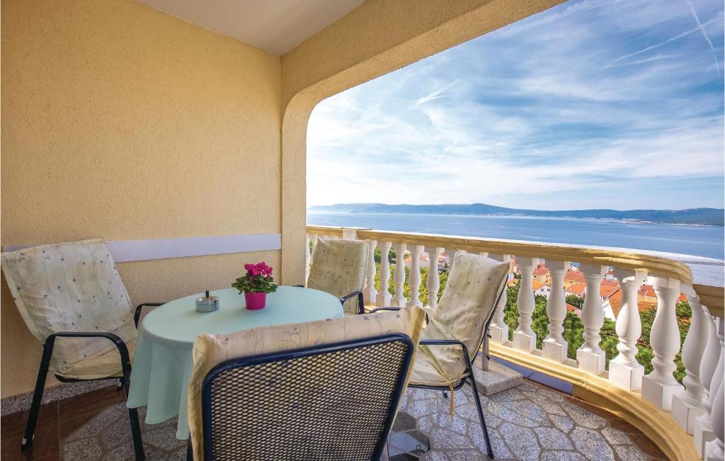 a table and chairs on a balcony with a view of the ocean at Awesome Apartment In Crikvenica With Wifi in Crikvenica
