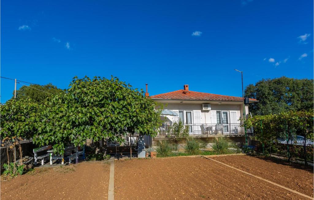 una pista de tenis frente a una casa en 2 Bedroom Stunning Home In Omisalj, en Omišalj