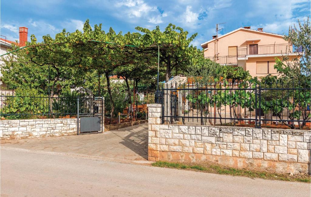 a stone fence with a gate in front of a building at Amazing Apartment In Galizana With Wifi in Galižana