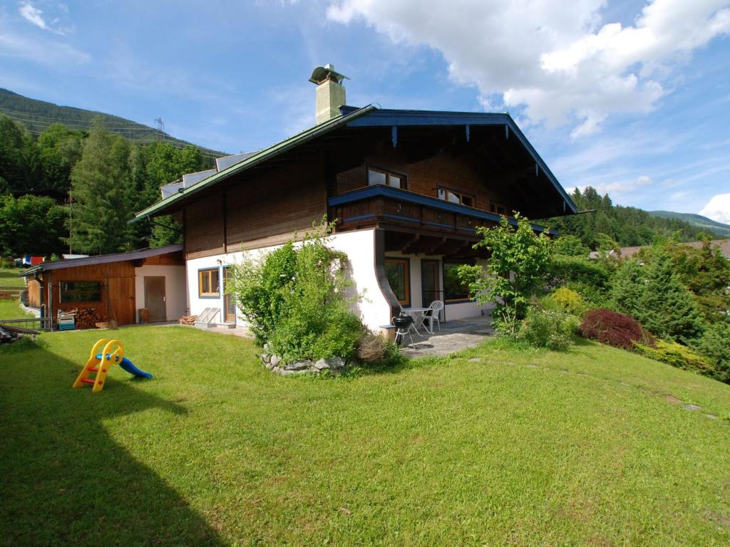 a house with a playground in front of it at Great group holiday home in Neukirchen am Großvenediger