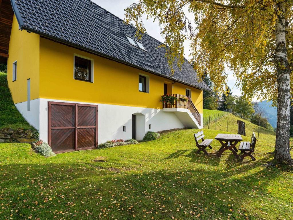 uma casa amarela e branca com uma mesa de piquenique em frente em Holiday home in Eberstein near Woerthersee em Eberstein