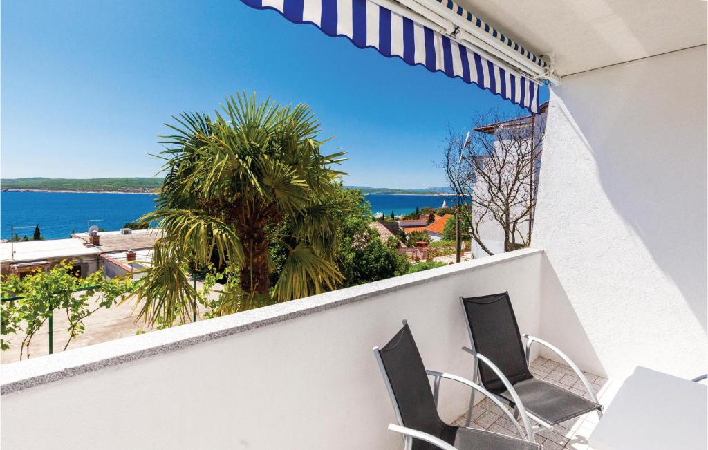 a balcony with two chairs and a view of the ocean at Beautiful Apartment In Crikvenica With Kitchen in Crikvenica