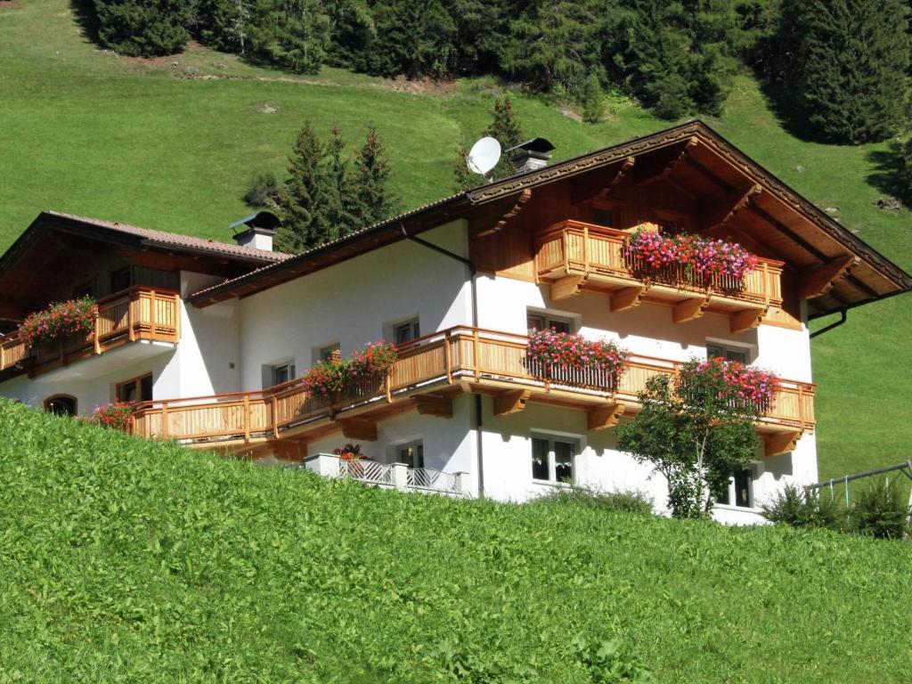 a building with balconies and flowers on a hill at Home with a wooden decor and full of atmosphere in Außervillgraten