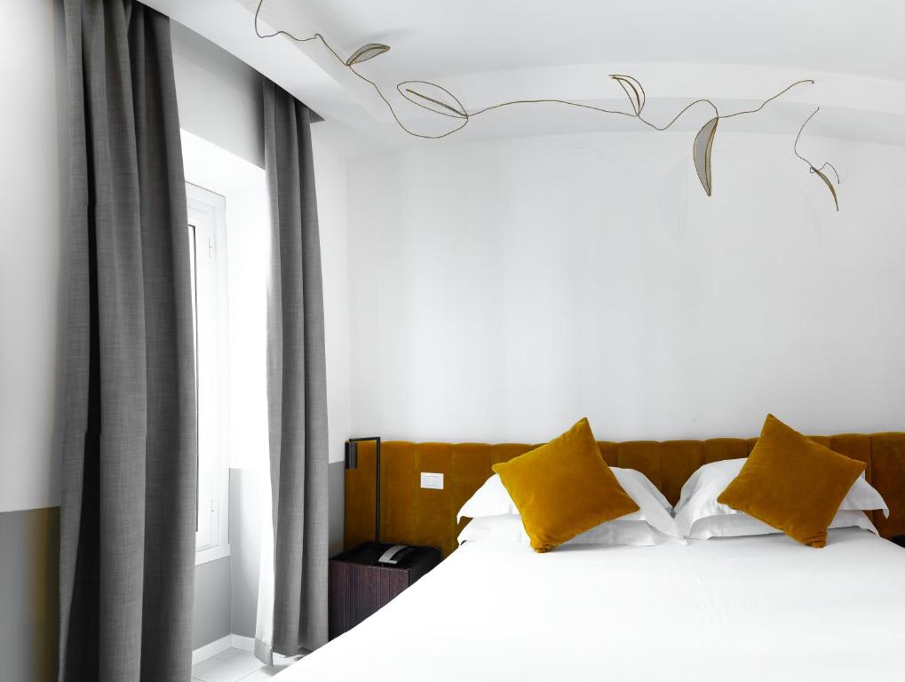 una camera da letto con un letto bianco con cuscini gialli di Old Town Home Trastevere a Roma