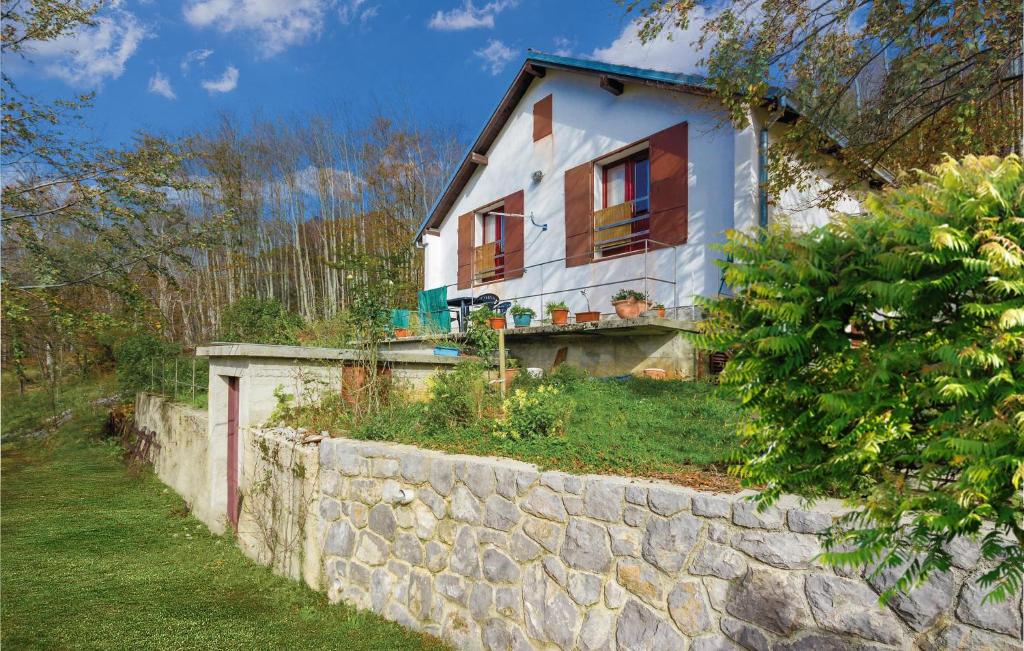 une petite maison blanche avec un mur en pierre dans l'établissement Awesome Apartment In Stolac With House A Panoramic View, à Žukalj