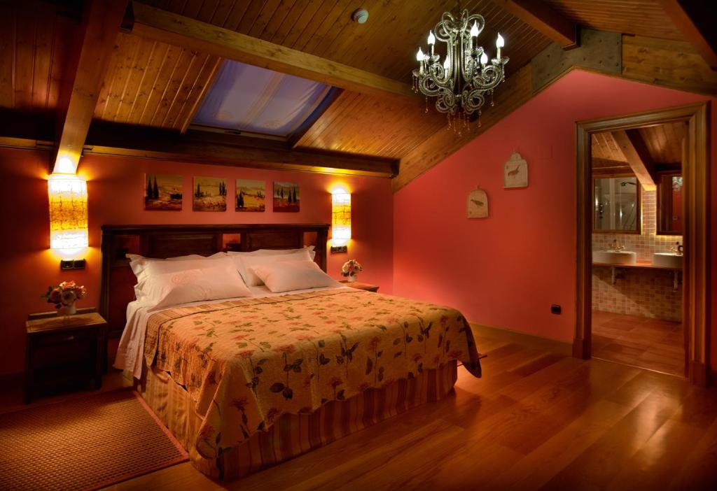 Schlafzimmer mit einem großen Bett mit roten Wänden in der Unterkunft Villa Ferrera Posada Rural in Herrera de Valdecañas