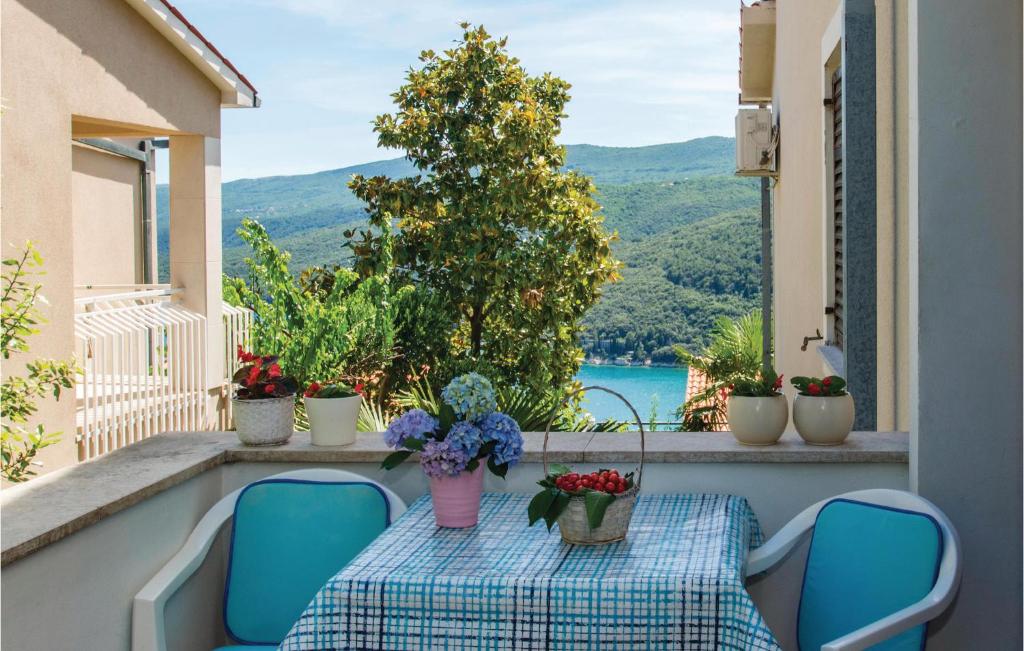 a table and chairs on a balcony with a view at Beautiful Apartment In Rabac With Kitchen in Rabac