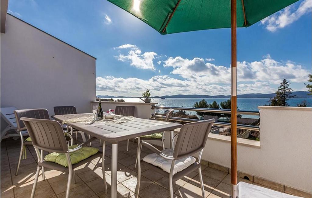 a table and chairs on a balcony with an umbrella at 2 Bedroom Amazing Apartment In Zadar in Zadar