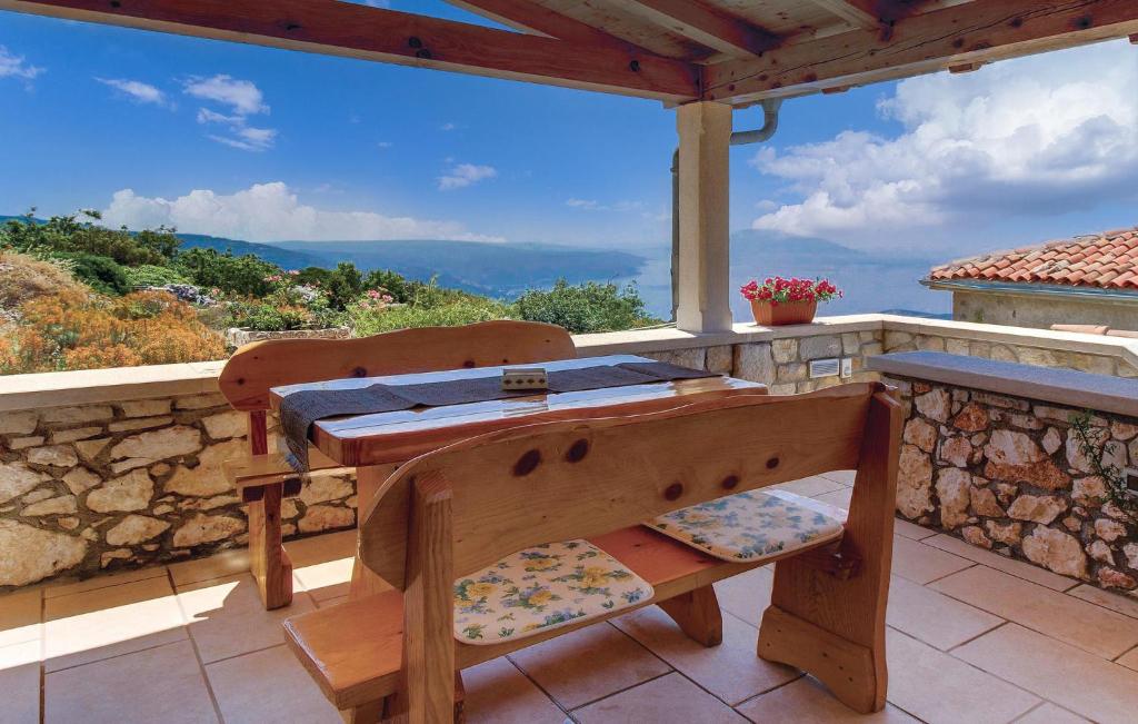 einen Holztisch und eine Bank auf einem Balkon mit Aussicht in der Unterkunft Awesome Home In Vidovici With 2 Bedrooms And Wifi in Vidović