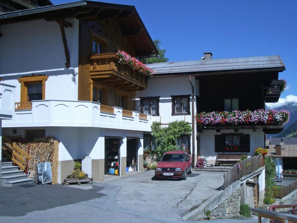 ein Haus mit einem roten Auto, das davor geparkt ist in der Unterkunft Gorgeous Apartment in Kappl Tyrol with Mountain Views in Kappl