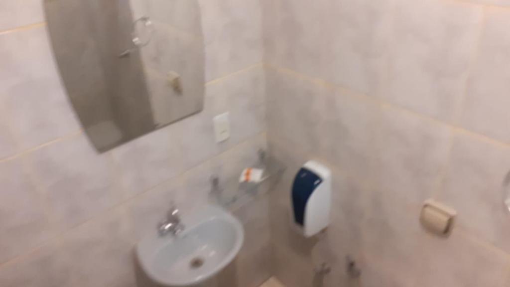 y baño con lavabo y espejo. en Pousada Fênix, en Pirenópolis