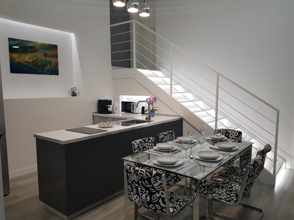 eine Küche mit einem Tisch und Stühlen sowie eine Treppe in der Unterkunft Duomo Platinum Apartments in Neapel