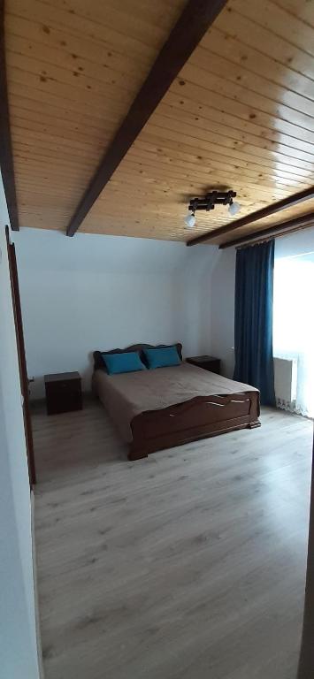1 dormitorio con cama y techo de madera en Nice House, en Slavske