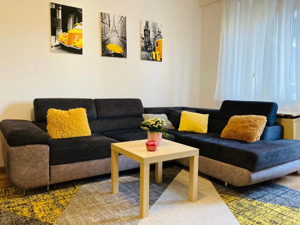 a living room with a blue couch and a table at Origo Apartman in Eger