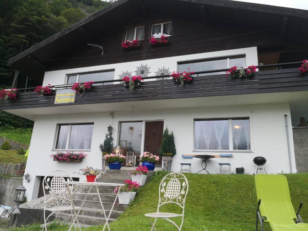 a white house with flowers on the balcony at Apartment Ferreira in Iseltwald