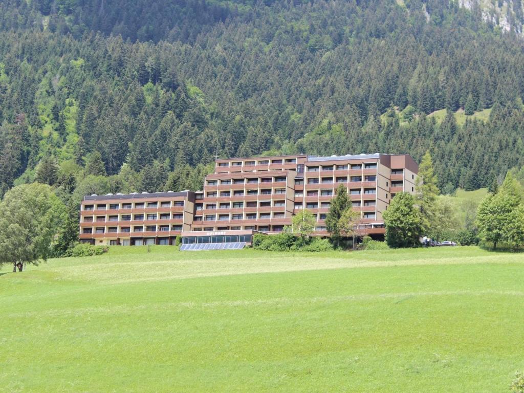 ein großes Gebäude mitten auf einem grünen Feld in der Unterkunft Holiday apartment in Tauplitz with sauna in Tauplitz