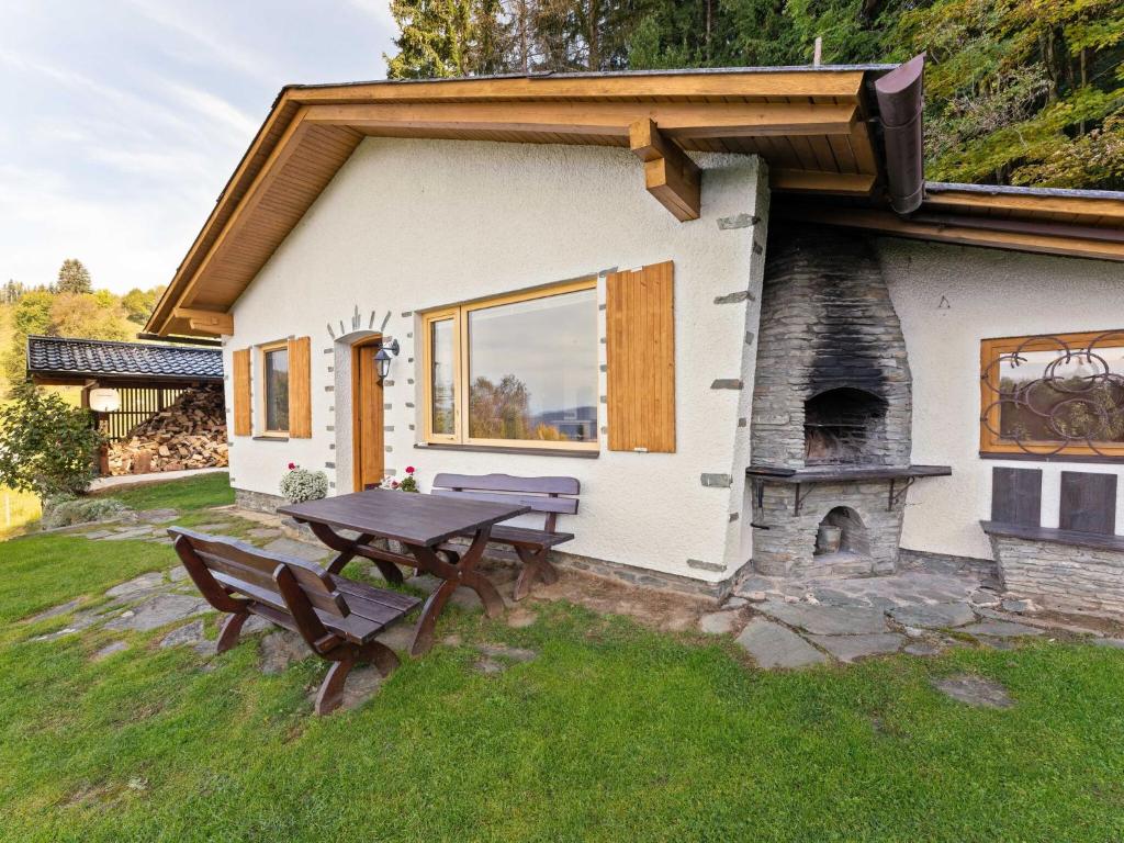 a picnic table in front of a house with a fireplace at Cosy holiday home with private pool in Eberstein