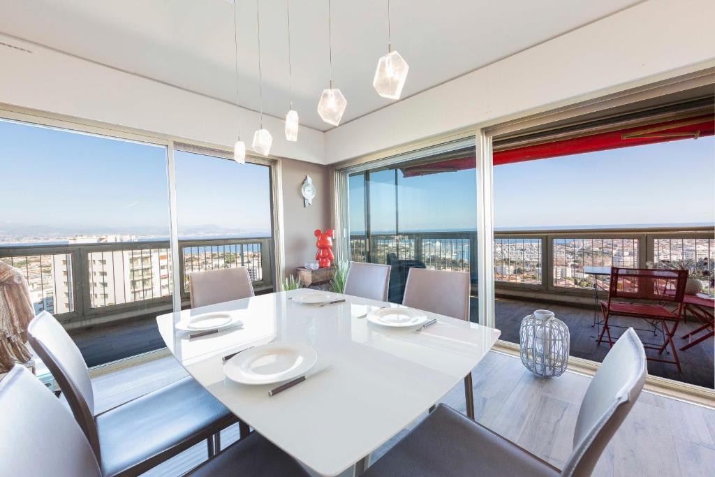 アンティーブにあるLe Chambord Breathtaking view 2 bedroom apartment in Antibes !のダイニングルーム(白いテーブル、椅子、大きな窓付)
