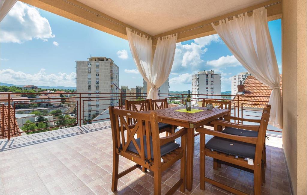 a wooden table and chairs on a balcony with a view at Amazing Apartment In Sibenik With Kitchen in Šibenik