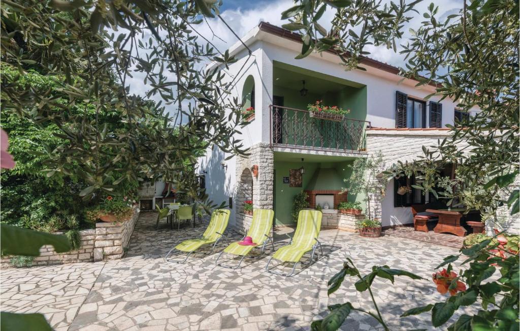 a house with a patio with yellow chairs at 3 Bedroom Lovely Home In Manjadvorci in Manjadvorci