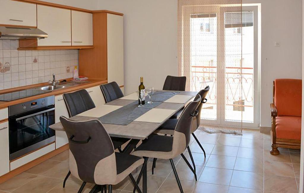 a kitchen with a table with chairs and a bottle of wine at Stunning Apartment In Senj With Wifi in Senj